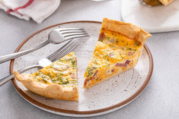 Homemade quiche with ham and cheese cut on the table