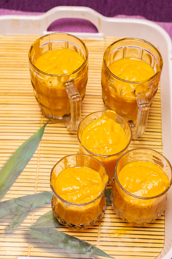 Traditional healthy drink with mango. Fresh lassi made of yogurt, mango, water, fruits and ice.Mango Lassi served in glasses and mugs.