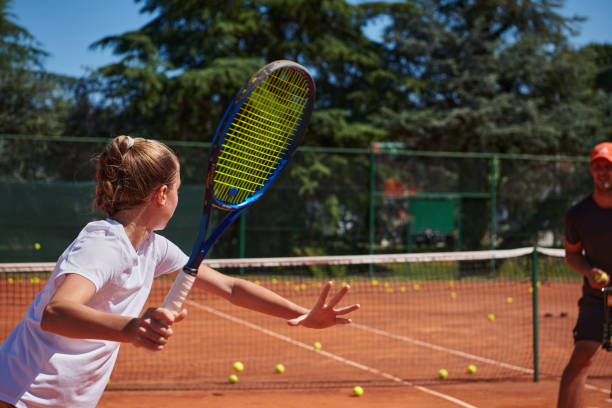 uma tenista profissional e seu treinador treinando em um dia ensolarado na quadra de tênis. treinamento e preparação de um tenista profissional - tennis coach serving playing - fotografias e filmes do acervo