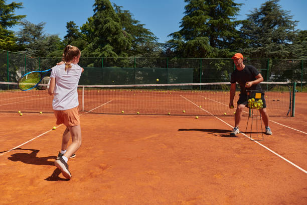 profesjonalna tenisistka i jej trener trenujący w słoneczny dzień na korcie tenisowym. trening i przygotowanie zawodowego tenisisty - tennis court sports training tennis net zdjęcia i obrazy z banku zdjęć