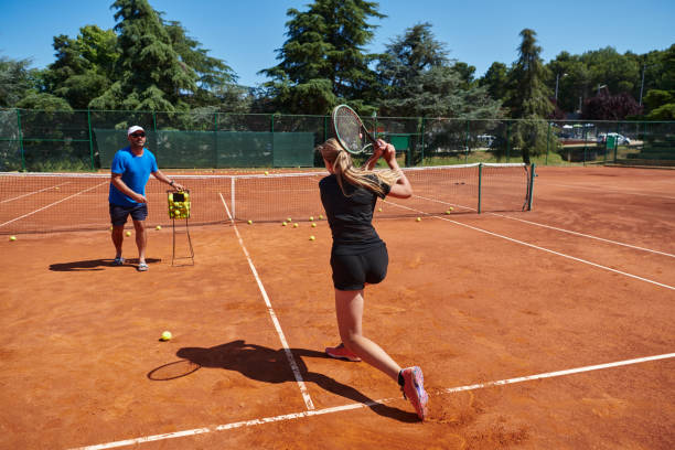 profesjonalna tenisistka i jej trener trenujący w słoneczny dzień na korcie tenisowym. trening i przygotowanie zawodowego tenisisty - tennis court sports training tennis net zdjęcia i obrazy z banku zdjęć