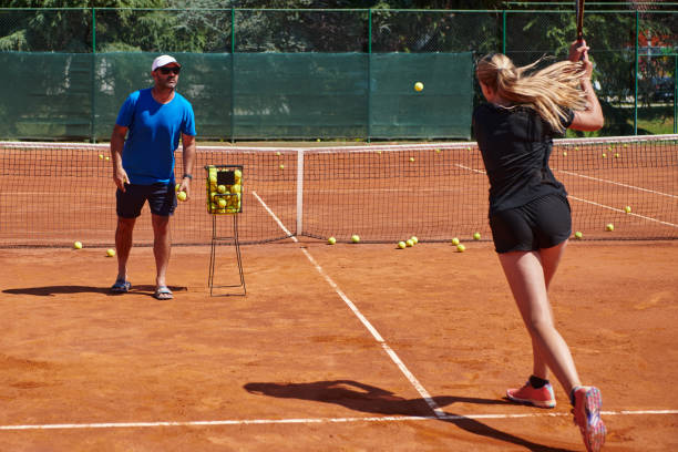 profesjonalna tenisistka i jej trener trenujący w słoneczny dzień na korcie tenisowym. trening i przygotowanie zawodowego tenisisty - tennis court sports training tennis net zdjęcia i obrazy z banku zdjęć