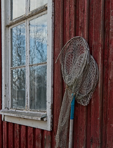 Old fishing net lies on wall of abandoned old building at Oulu, Finland.