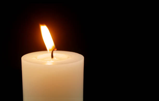 istock White candle isolated on black background. 1492516245