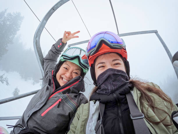 madre anciana asiática, hija multirracial se toma una selfie en el telesilla - mt seymour provincial park fotografías e imágenes de stock