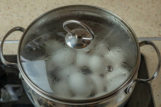 istock Iron pan with boiling water in which white chicken eggs are boiled. Water boils and boils in pan with boiled chicken eggs. Process of cooking eggs on gas stove. Chef prepares eggs. Zoomed close-up 1492525179