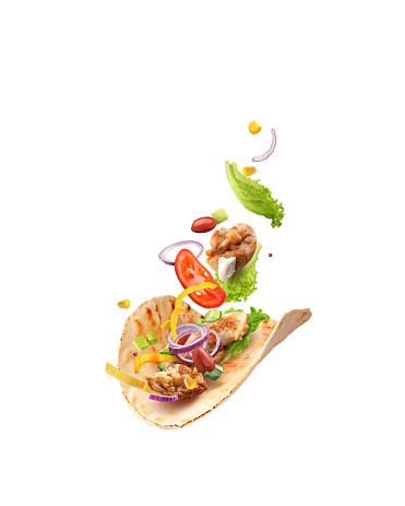 burrito with chicken meat and vegetables in flight on a white background