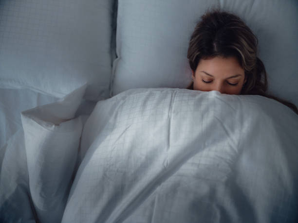 istock Relaxed woman sleeping in bed at night. 1492530577