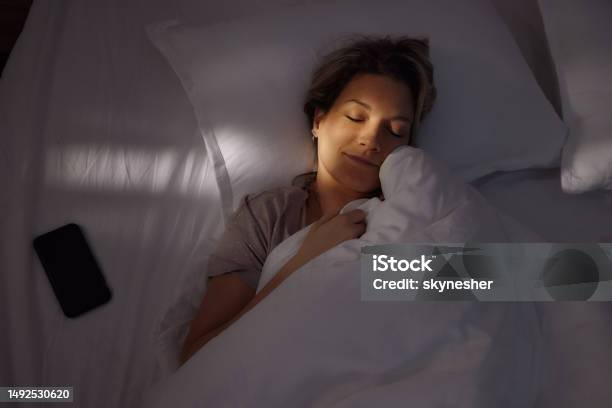 Serene Woman Sleeping In Bed At Night Stock Photo - Download Image Now - Sleeping, Night, Women