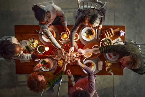 istock Above view of happy friends toasting during lunch at dining table. 1492531718