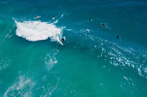 Surfer ride on surfboard on wave in blue ocean. Aerial view