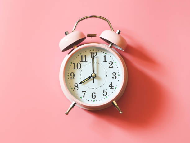 la disposición plana del reloj despertador vintage rosa muestra las 8 en punto sobre fondo rosa con espacio de copia. - 8 oclock fotografías e imágenes de stock