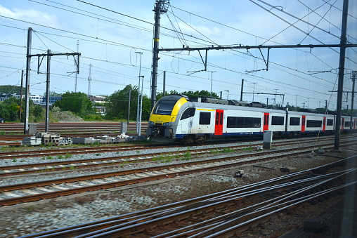 Gent, East-Flanders, Belgium - May 20, 2023: view on passengers train from inside another train direction Belgian coast after leaving Ghent-Sint-Pieters railway station