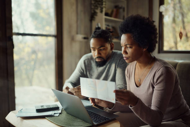 istock Black couple paying their bills over a computer at home. 1492533590