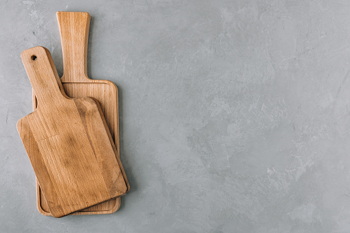 Chopping boards. Empty wooden cutting boards on gray stone background. Top view, copy space.