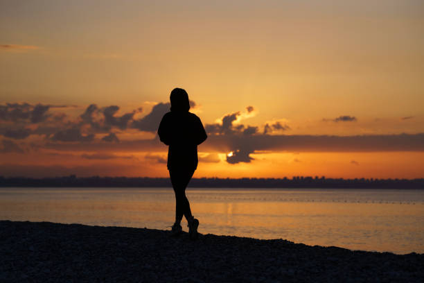 Young woman running on the beach at sunrise