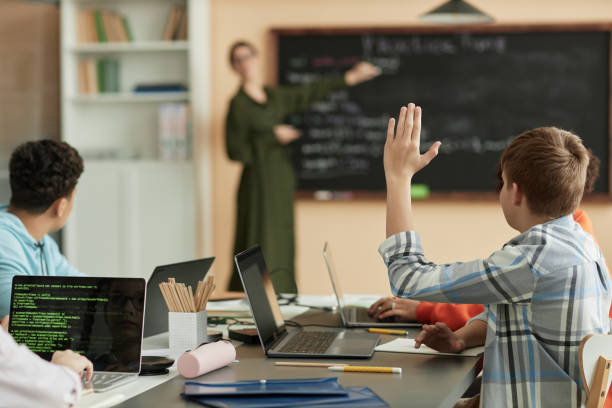 istock Teen boy raising hanswering question in class at school 1492537730