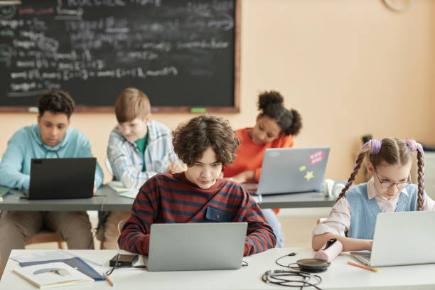 istock Group of school children using laptops in class 1492537760