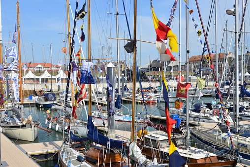 Blankenberge, West-Flanders, Belgium - May 20, 2023: at this event yachting club owners decorate their boats with colorful pennant flags on the mast ships in the marina