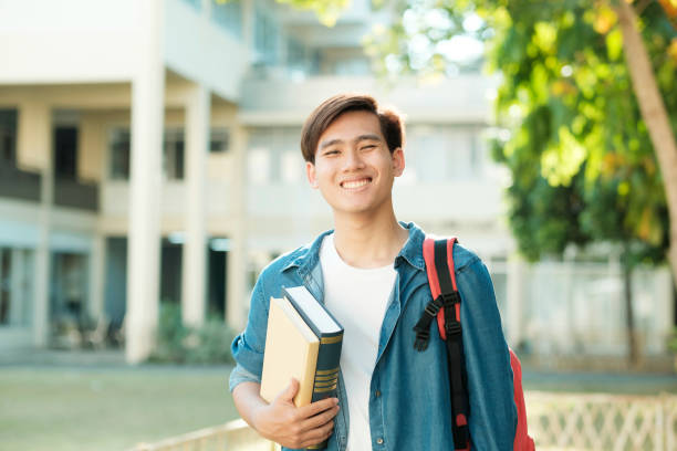 istock Student standing outdoor and holding books. 1492541572