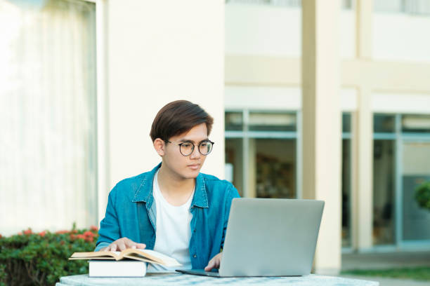 student studying outdoor using laptop. - using laptop contemplation accessibility contemporary imagens e fotografias de stock