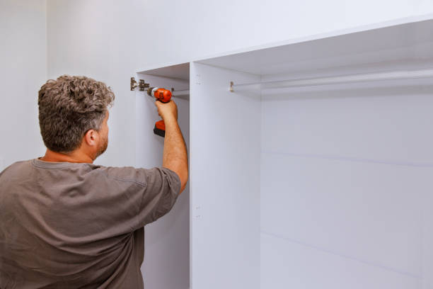 istock Carpenter working on assembling furniture closet cabinets that needed to be installed in the room 1492544049