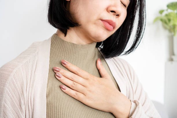 Close-Up of Asian Woman Experiencing Shortness of Breath and Panic Attack, stock photo