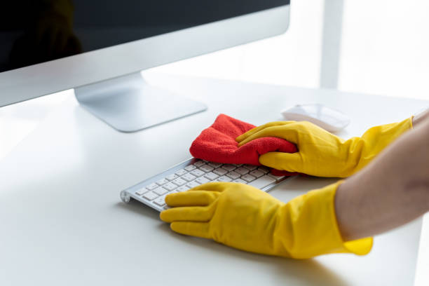 istock Person cleaning room, cleaning worker is using cloth to wipe computer keyboard in company office room. Cleaning staff. Concept of cleanliness in the organization. 1492546046