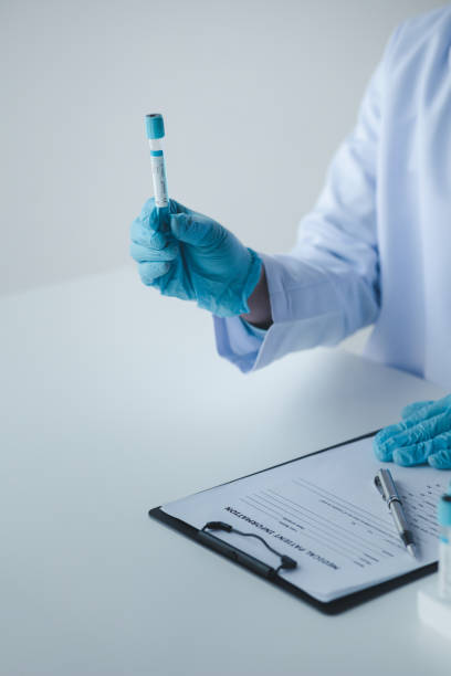 Lab assistant, a medical scientist, a chemistry researcher holds a glass tube through the blood sample, does a chemical experiment and examines a patient's blood sample. Medicine and research concept. asistente de laboratorio, un científico médico, un investigador de química sostiene un tubo de vidrio a través de la muestra de sangre, hace un experimento químico y examina la muestra de sangre de un paciente. concepto de medicina e investigación.