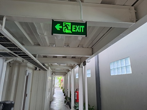 Emergency exit sign with left arrow in public areas
