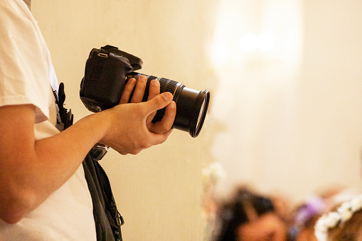 hands holding a professional camera. photographer filming an event