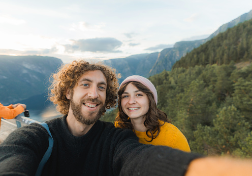 Selfie of  young Caucasian man  and woman on the background of fjord  in Norway