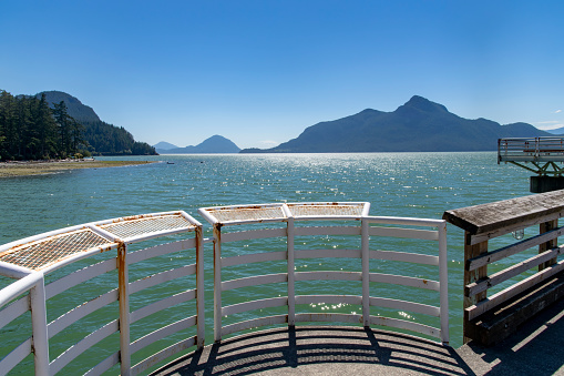 View from ferry dock and pier of Porteau Cove Provincial Park near Squamish, BC, Canada, along the Howe Sound with in background, mountains of Tetrahedron Provincial Park