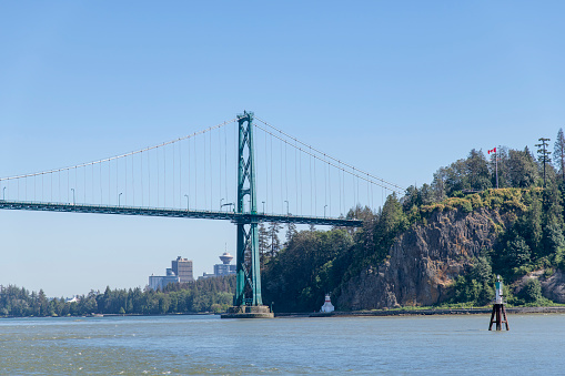 View to south Lions Gate Bridge, Vancouver, BC, Canada, that crossing first narrows of Burrard Inlet and connects to North Shore municipalities, with view on Stanley Park and Prospect Point Lighthouse