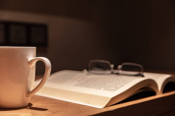 istock Open book with glasses and white coffee cup on wooden table 1492550497