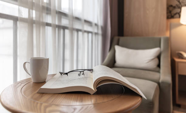 istock Books and a cup of coffee on a round table by the window 1492550542