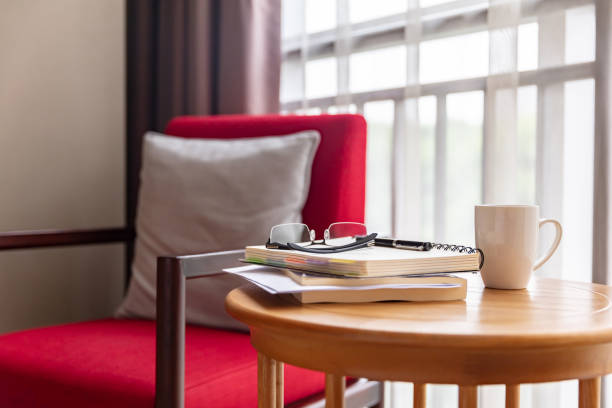 Red sofa in room with glasses, book and coffee on round table