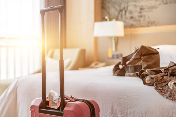 istock Hotel room with big bed sofa and red suitcase, guest just checked in 1492550713