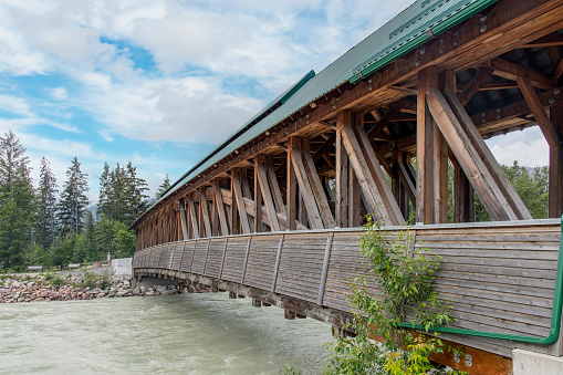 Golden, BC, Canada-August 2022; View of the Kicking Horse Pedestrian Bridge, the longest freestanding timber frame bridge in Canada, spanning the Kicking Horse River in downtown Golden