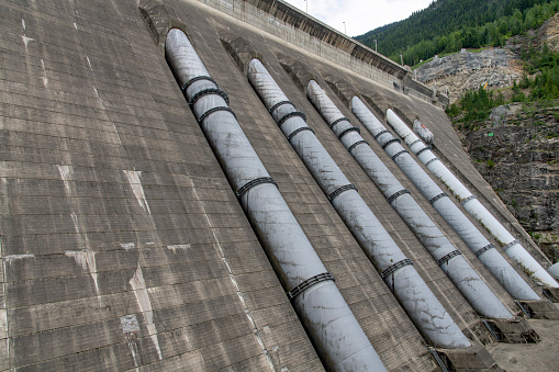 Revelstoke, BC, Canada-August 2022; Close up of the penstocks or pipes of the hydroelectric Revelstoke Dam spanning the Columbia River with five generating units behind the Lake Revelstoke reservoir