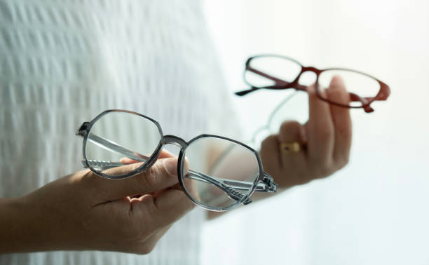 istock Close-up of a female hands client showing two glasses, making a choice. Blurred background 1492553846