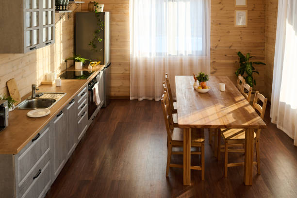 istock Spacious kitchen with wooden table and chairs, long counter and refrigerator 1492554820