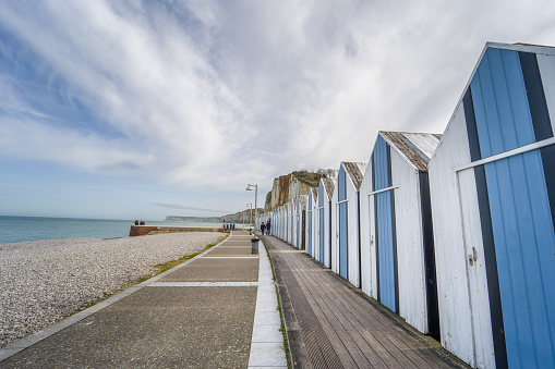This stunning photo captures the coastal charm of Yport, Normandy, France. Along the promenade, you can admire the beach houses in shades of blue and white, adding a vibrant touch to the landscape.