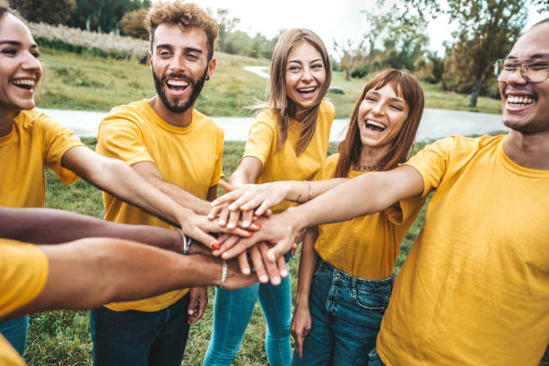 istock Multi ethnic young people team stacking hands together outside - International university students support and help each other - Friendship, team building, human relationship and diversity concept 1492557867