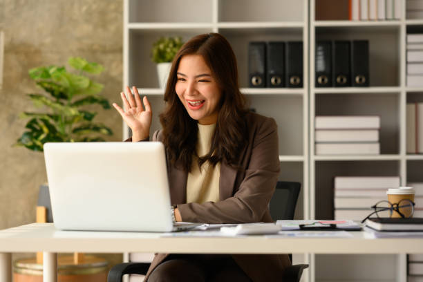 istock Cheerful female entrepreneur consulting client online, discussing working issues remotely via laptop at workplace. 1492558037