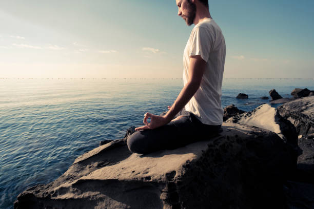 istock Attractive young man practicing yoga meditation and breathwork outdoors by the sea 1492558317