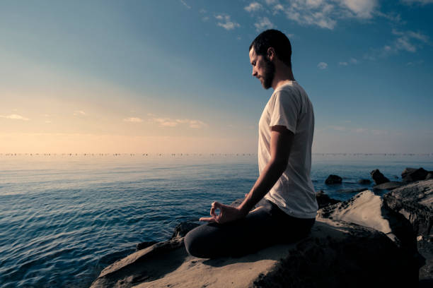 istock Attractive young man practicing yoga meditation and breathwork outdoors by the sea 1492558406