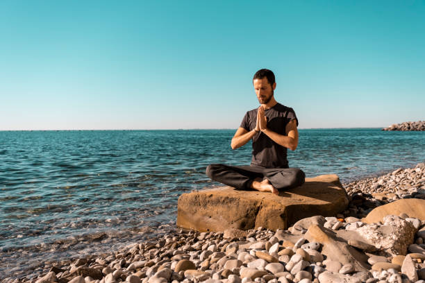 istock Attractive young man practicing yoga meditation and breathwork outdoors by the sea 1492558626