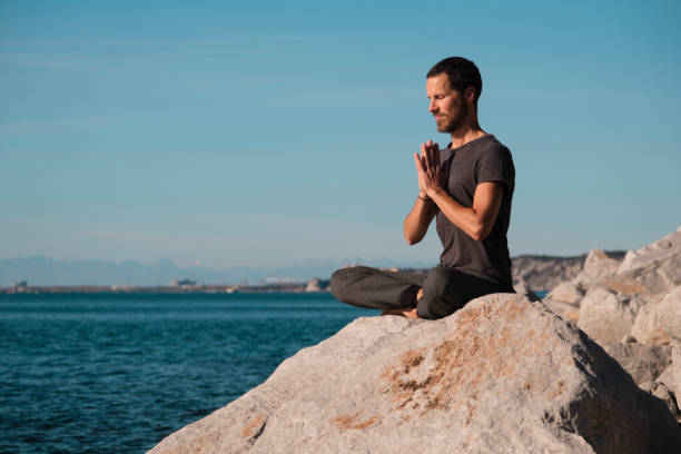 istock Attractive young man practicing yoga meditation and breathwork outdoors by the sea 1492558790