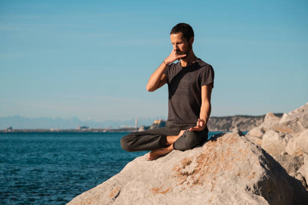 istock Attractive young man practicing yoga meditation and breathwork outdoors by the sea 1492558867